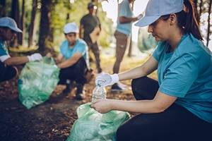 Volunteers picking up trash in the woods.