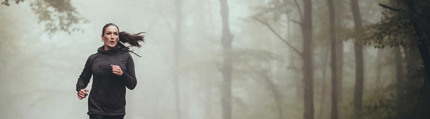 woman running on road in woods