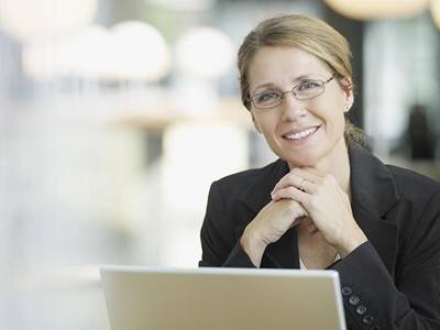 Woman smiling while sitting at laptop