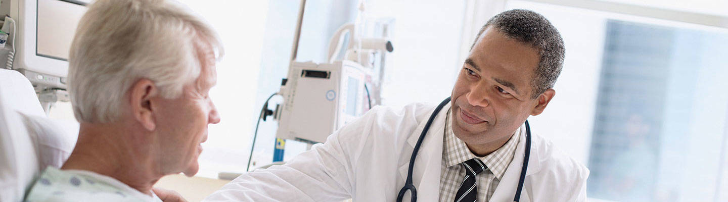 doctor visiting man in hospital bed