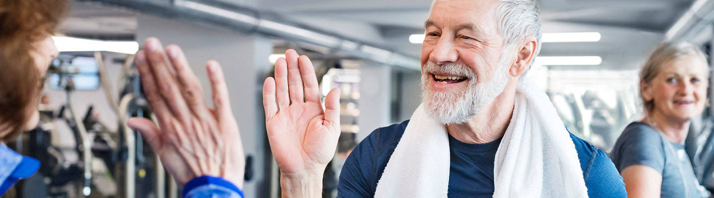 Man high fives therapist after rehab session