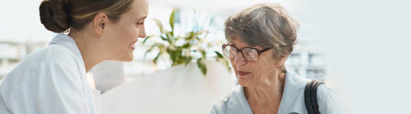 Pharmacist explains medication to senior woman