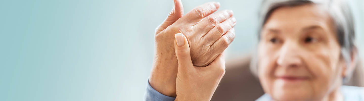 senior woman holding up hand for nurse