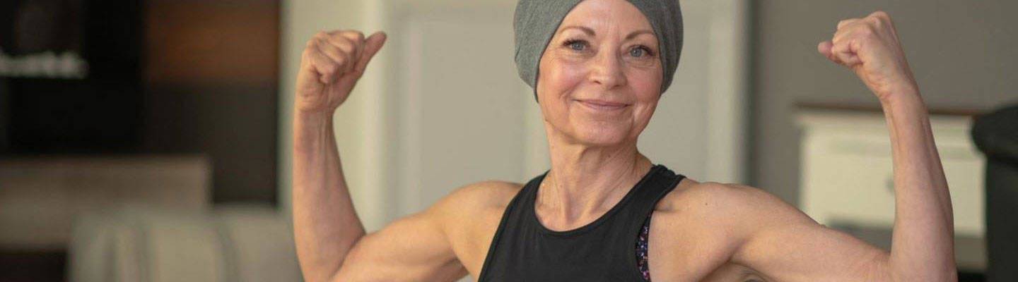 Woman with cancer raising hands in victory