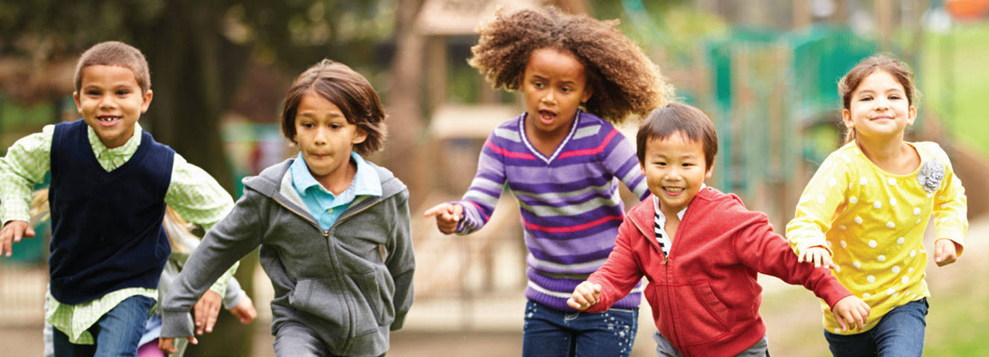 Diverse group of children running on playground