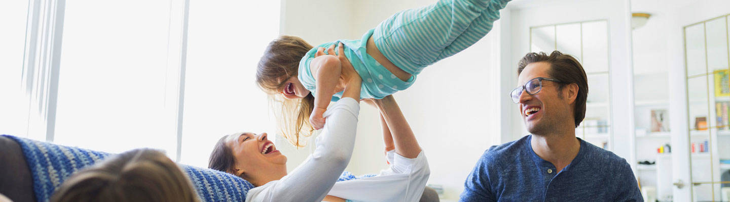 Mom lifting daughter up in air