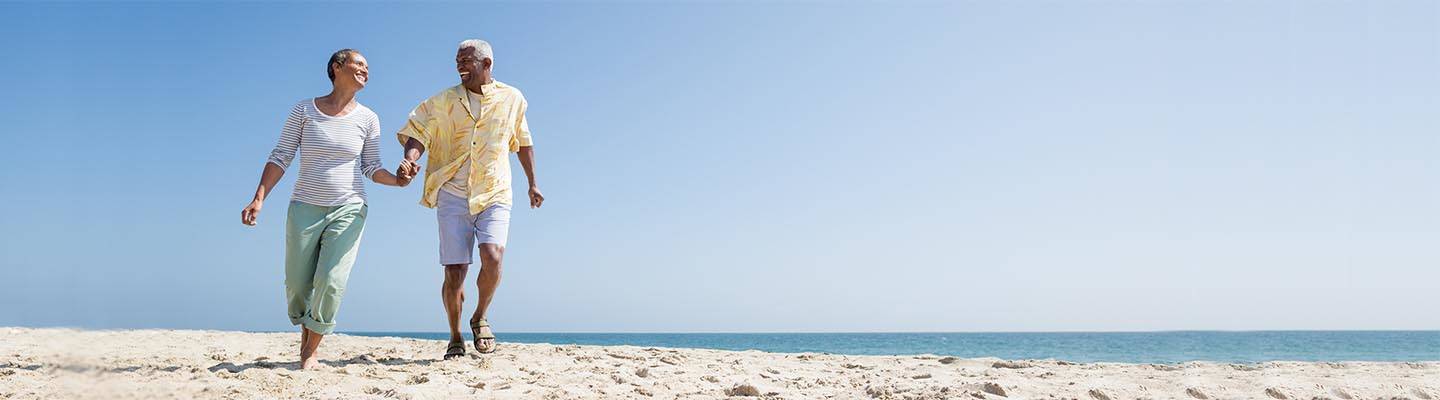 Mature couple walking along beach