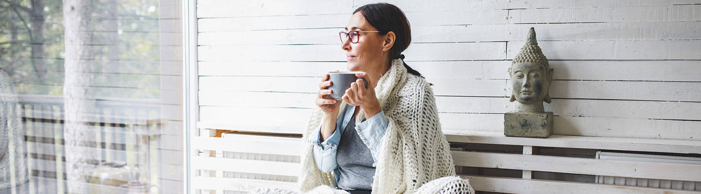 woman drinking tea looking out window