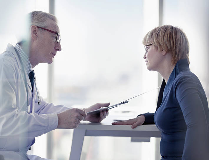 Doctor and patient reviews diagnosis while seated in office