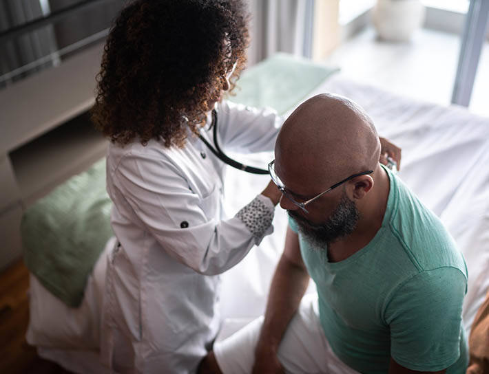Doctor using stethoscope on patient