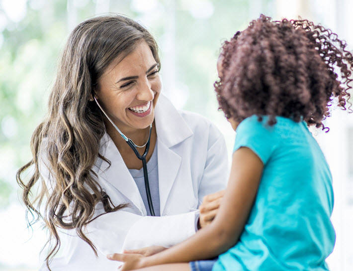 Doctor checks girls heart rate with stethoscope
