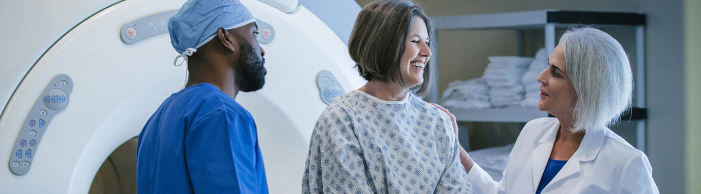 Imaging team with patient near imaging equipment. 