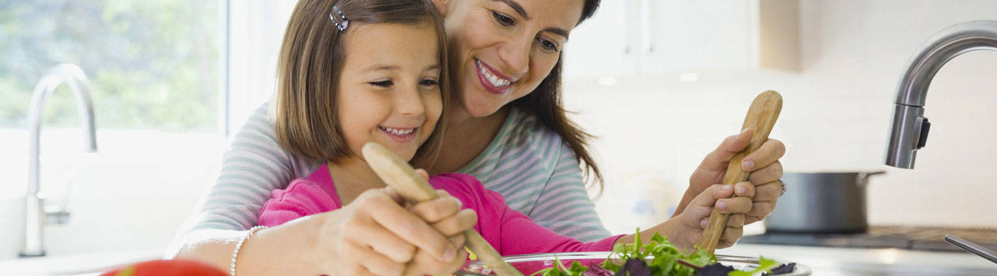Woman and young child preparing a salad