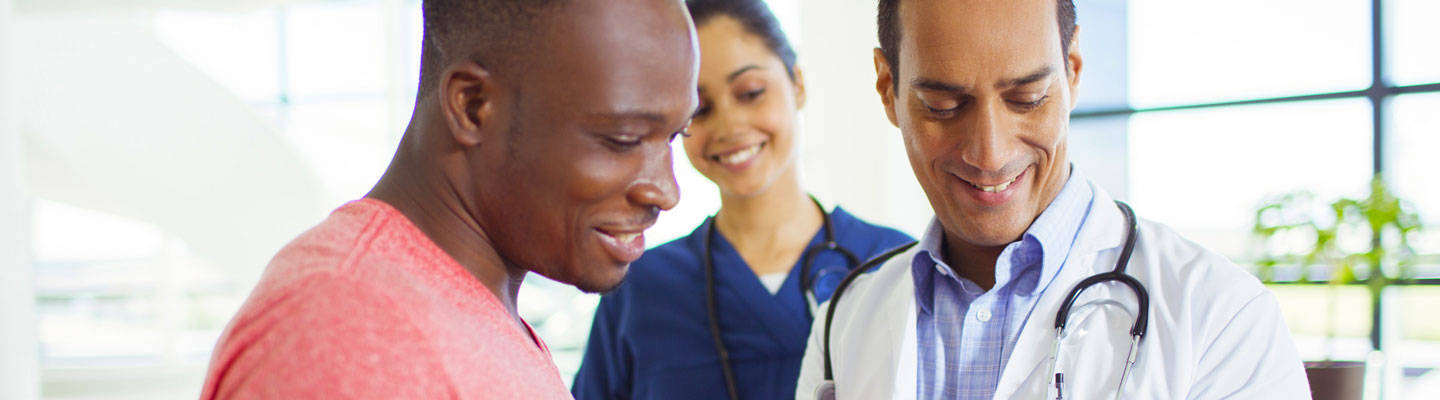 Doctor smiles with patient as they look at his file
