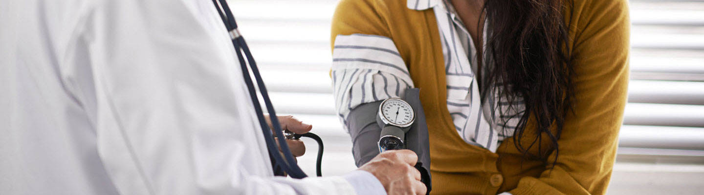 Doctor taking blood pressure of patient.